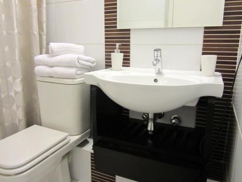 ein Badezimmer mit einem weißen Waschbecken und einem WC in der Unterkunft Lobato Apartments in Santiago
