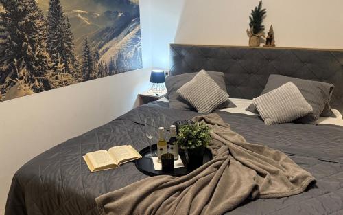 a bed with a blanket and wine bottles on it at Apartmán Mlýn Herlíkovice 205 in Vrchlabí