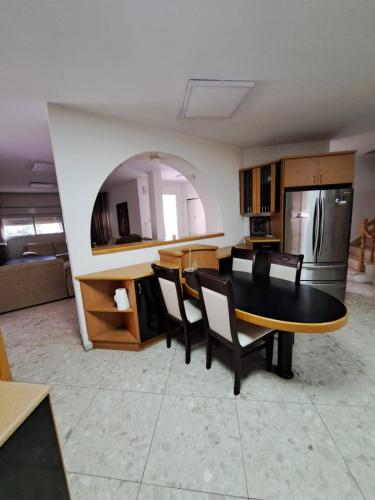 a kitchen with a table and chairs in a room at הוילה בעומר in ‘Omer