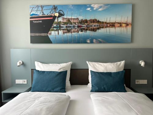 a bedroom with two beds and a boat on the water at Hotel Schöne Aussicht in Wilhelmshaven