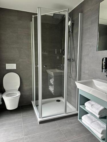 a bathroom with a shower and a toilet and a sink at Hotel Schöne Aussicht in Wilhelmshaven