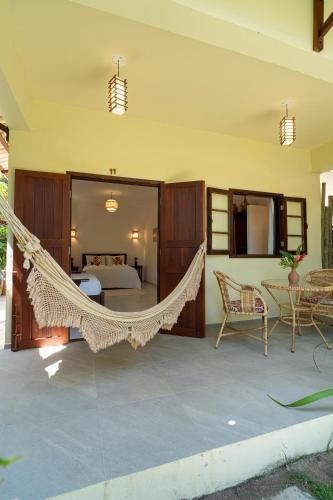 a hammock in a room with a bedroom at Pousada Samambaia in Trancoso