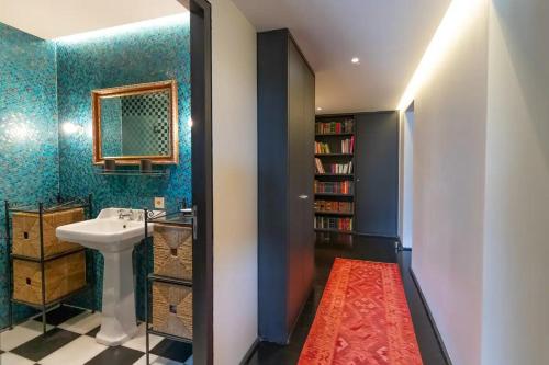 La salle de bains est pourvue d'un lavabo et d'une étagère. dans l'établissement Nouveau, très bel appartement avec jardin, à Biarritz