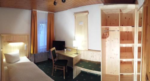 um quarto com uma secretária, uma cama, uma secretária e um computador em Gasthaus Zur Ölmühle em Oberderdingen