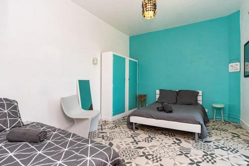 une chambre avec un lit et un mur bleu dans l'établissement Villa Olympe, à Montauban