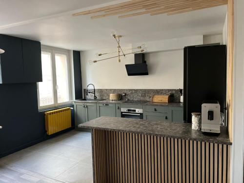 une cuisine avec des armoires bleues et un comptoir dans l'établissement Appartement d'Exception à Saint-Étienne Spacieux 100m2 Haut de Gamme avec 2 Chambres, à Saint-Étienne