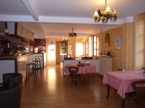 une cuisine et une salle à manger avec des tables et des chaises dans l'établissement Chambres d'hôtes - Domaine de la Grangeotte, à Labesserette