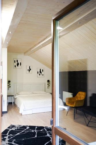 a bedroom with a white bed and a chair at Готель-ресторан Два Леви in Slavske