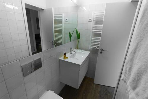 a white bathroom with a sink and a mirror at Oporto City View - Santa Catarina in Porto
