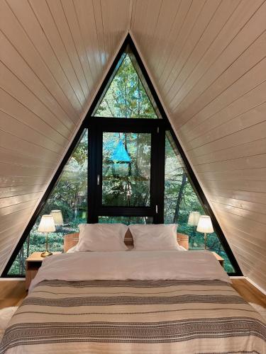 a bed in a room with a large window at Aret House in Avrig