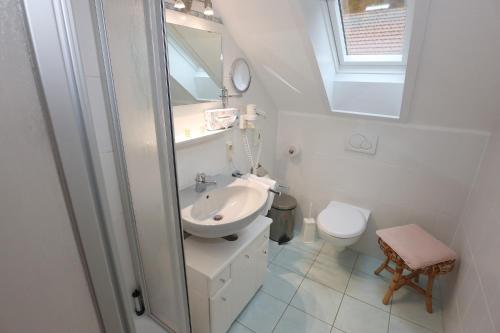a white bathroom with a sink and a toilet at Landgasthaus Kurz Hotel & Restaurant am Feldberg - Schwarzwald in Todtnau