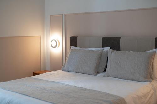 a bed with white sheets and pillows in a bedroom at Il Leccio Verde in Lecce