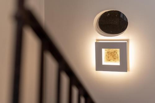 a light on a wall with a picture and a mirror at Il Leccio Verde in Lecce