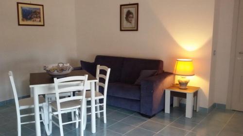 a living room with a couch and a table and chairs at Il Balcone delle Dee in Agerola