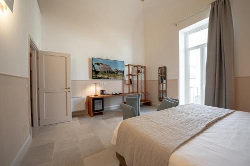 a bedroom with a bed and a desk and a window at Il Leccio Verde in Lecce