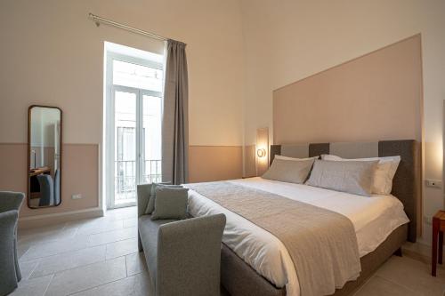 a bedroom with a large bed and a chair at Il Leccio Verde in Lecce