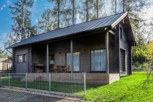 a small wooden house with a metal roof at Finskä chata in Samopše