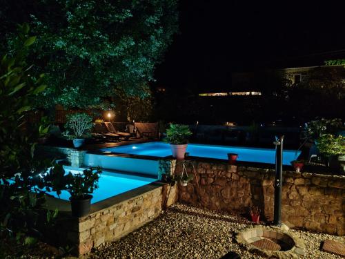 a swimming pool lit up at night at La musardière in Les Assions