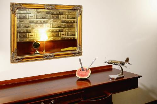 a desk with a mirror and a bowl of watermelon at Hotel Imperium in Chełmża