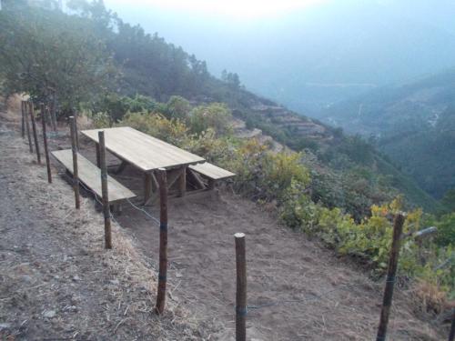 a picnic table on a hill overlooking a valley at Casa da Quelha in Chãs de Égua