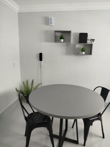a white table and two chairs in a room at Apartamento aconchegante 1911 in Goiânia