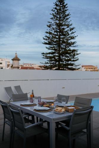 a table with chairs and a tree on a patio at Portugal Alma Villa Algarve - Luxury Villa with Private Pool in Alcantarilha