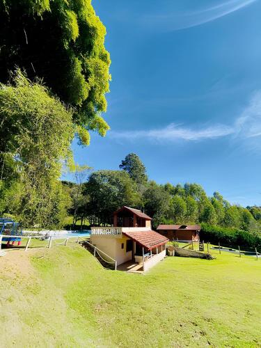 a small building in a field with trees in the background at Pousada Domos Serra do Sol in Monte Verde