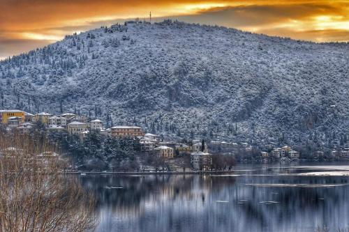 a mountain with a town on top of a lake at La maisonnette in Árgos Orestikón