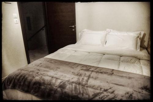 a bed with white sheets and pillows in a bedroom at La maisonnette in Árgos Orestikón