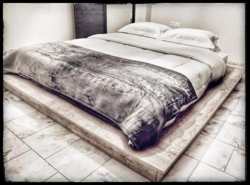 a large bed on a wooden platform in a bedroom at La maisonnette in Árgos Orestikón