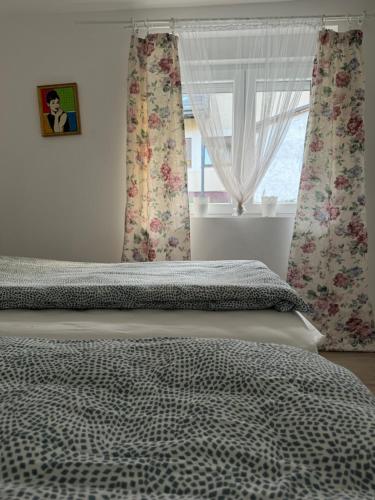 a bedroom with a bed and a window with curtains at Vila Lela in Vrnjačka Banja