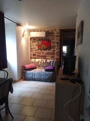 a room with a bed and a stone wall at La musardière in Les Assions