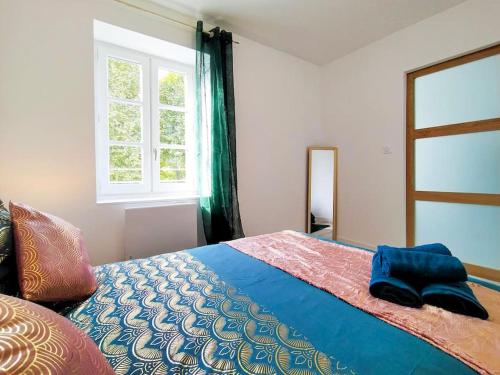 une chambre avec un lit avec une couverture bleue et une fenêtre dans l'établissement L'Isère depuis les Quais Romanais, à Romans-sur-Isère