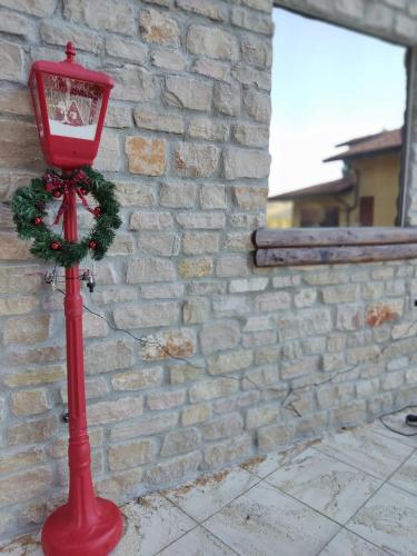 a red lamp with a wreath on it next to a brick wall at Chalet del Lago Laceno in Villaggio Laceno