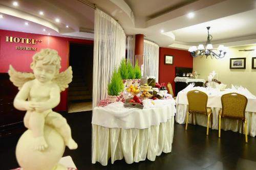a room with a table with a statue of an angel at Hotel Imperium in Chełmża