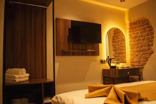 a hotel room with a bed and a flat screen tv at Galata Calm Tale Hotel in Istanbul