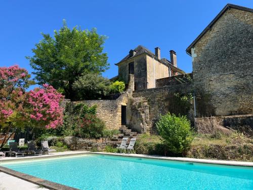 une vieille maison avec une piscine devant un immeuble dans l'établissement Proche de SARLAT -Vue exceptionnelle, à Carlux