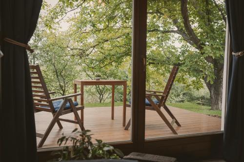 two chairs and a table outside a window at Suttogó Vendégház in Ságvár