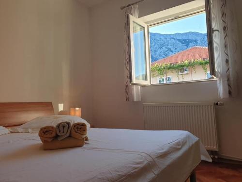 a bedroom with a white bed with a window at Apartment LoLi in Orebić