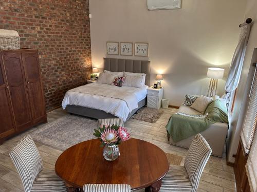 a bedroom with a bed and a table and a couch at Piekfijn Robertson in Robertson