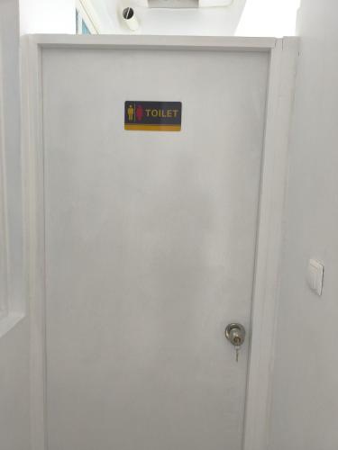 a white door with a toilet sign on it at Plateau Bedroom & Chambre - Praia Center 1 in Praia
