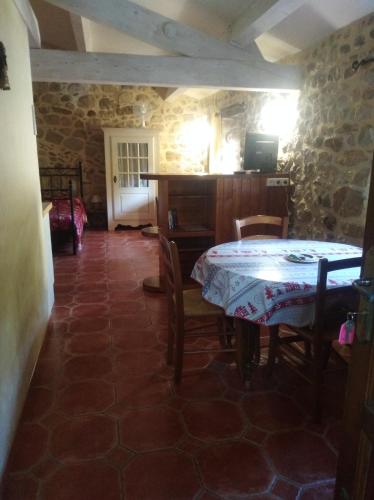 a dining room with a table and chairs in a building at La musardière in Les Assions