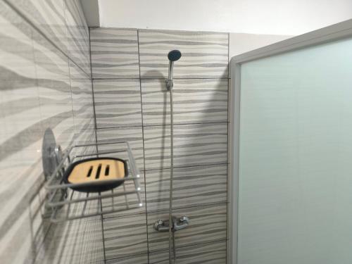 a shower with a glass door with a sink and a shower at Plateau Bedroom & Chambre - Praia Center 1 in Praia
