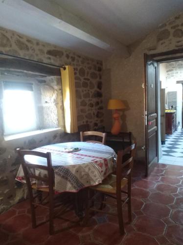 a dining room with a table and chairs and a window at La musardière in Les Assions