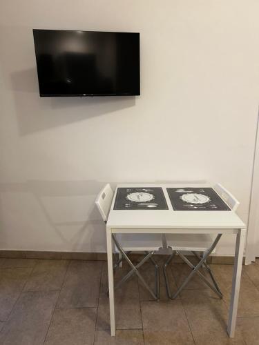 een witte tafel met een tv aan een witte muur bij Monolocale 1 in Turijn