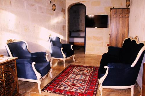 a living room with blue chairs and a rug at Timur inn Cappadocia in Goreme