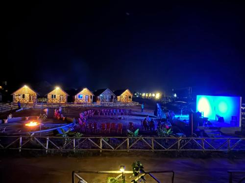 a group of people standing in front of houses at night at Mowgli's Cafe Hampi & Guest House in Hampi