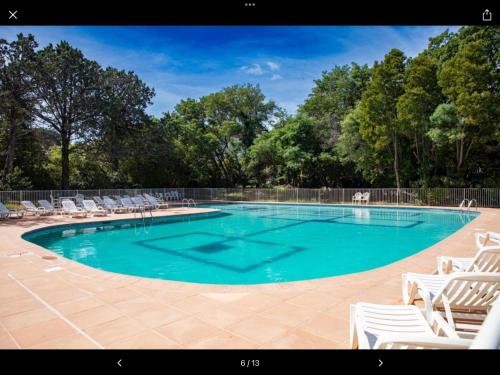 a large swimming pool with white lounge chairs at Studio RED MASTER in Saint-Tropez