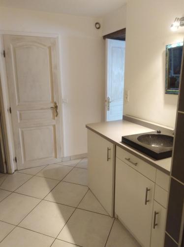 a kitchen with a sink and a door at La musardière in Les Assions