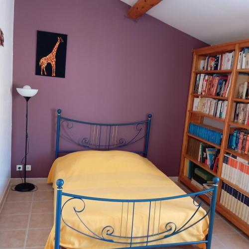 une chambre avec un lit et une étagère dans l'établissement Maison La p'tite pause, à Piolenc
